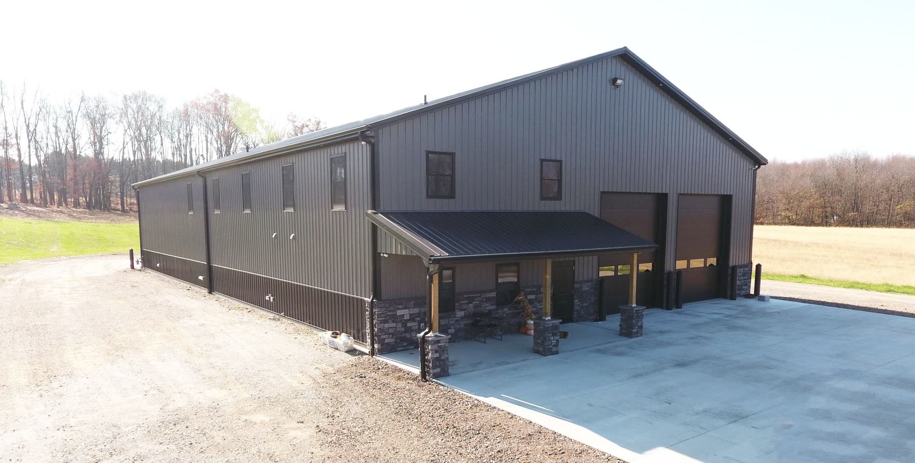 Finished equipment storage building with covered stone-accented entry