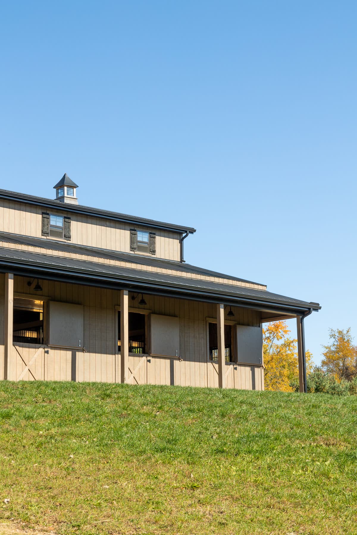 Upward view of the Ashland County barn's cupolas and roofline against a blue sky