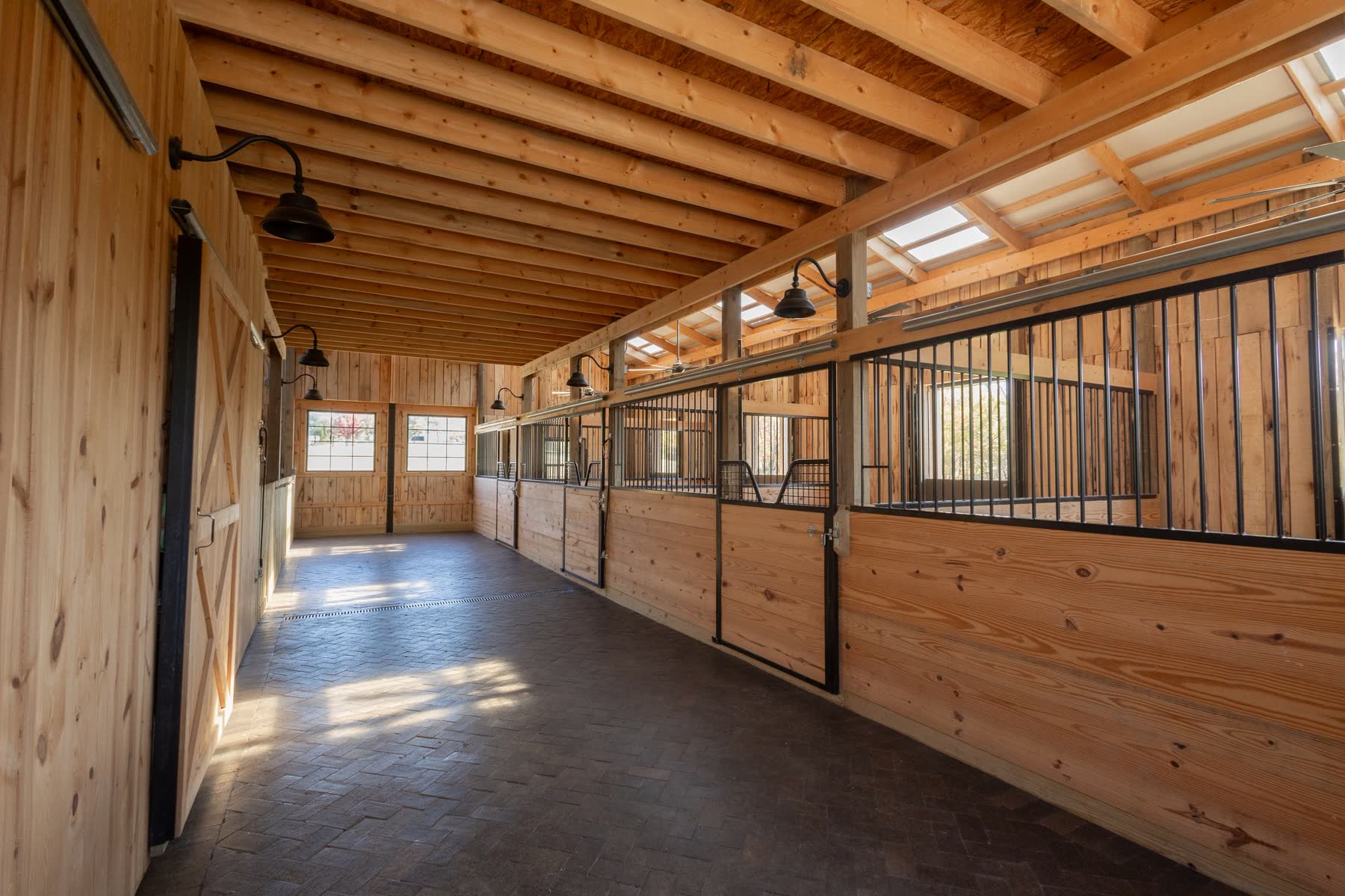 Finished interior aisle of the Ashland County equestrian barn with stalls