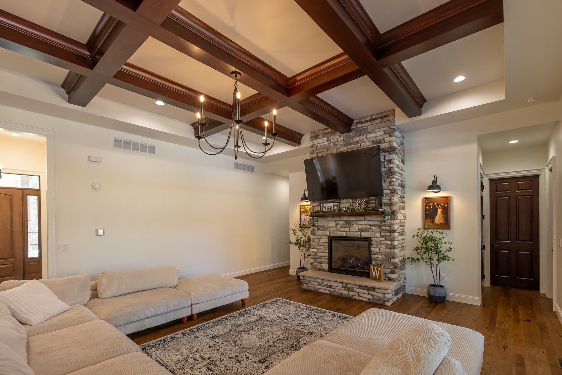 Living room with coffered wood ceiling and stone fireplace