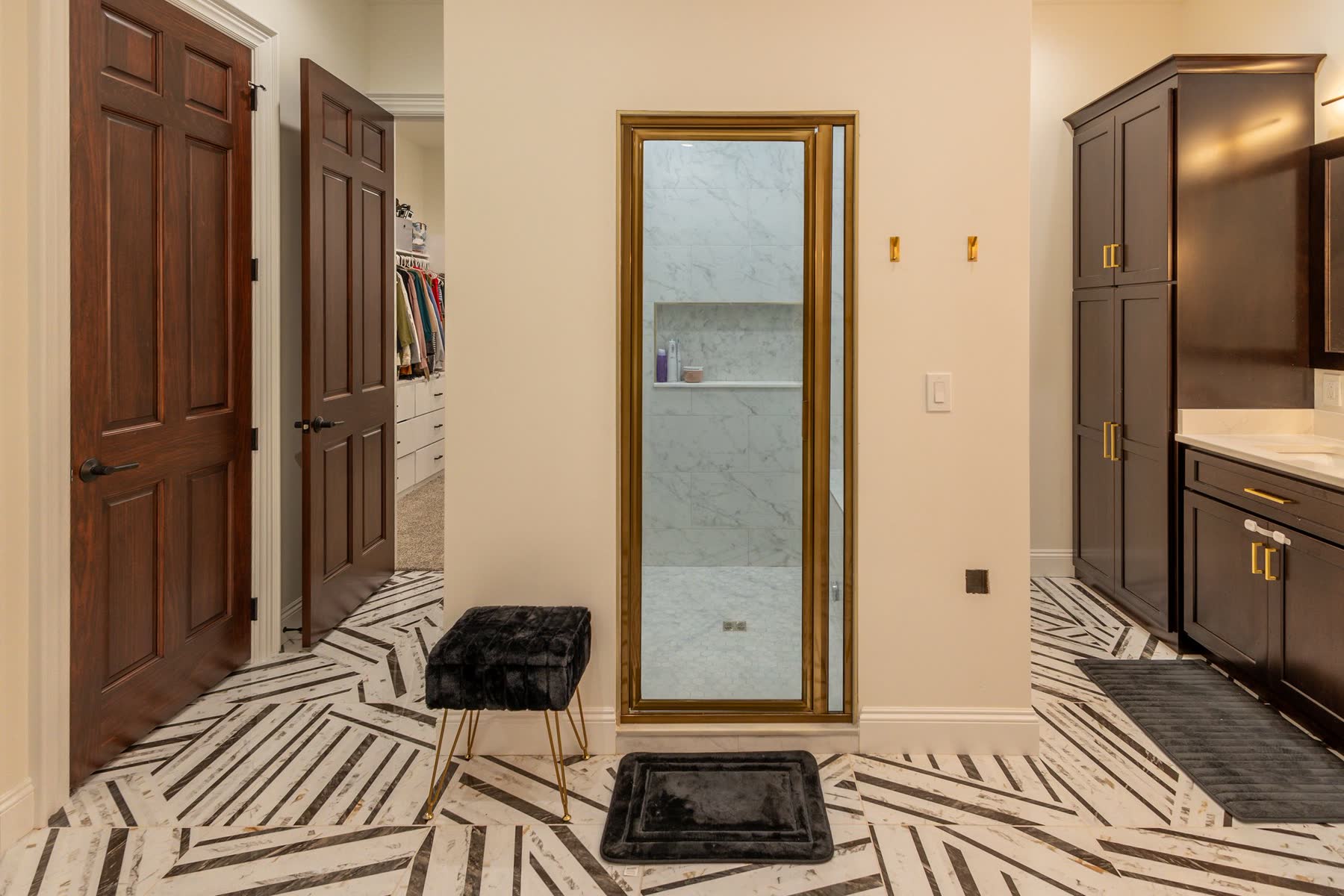 Primary bathroom with marble tile and dark wood vanities