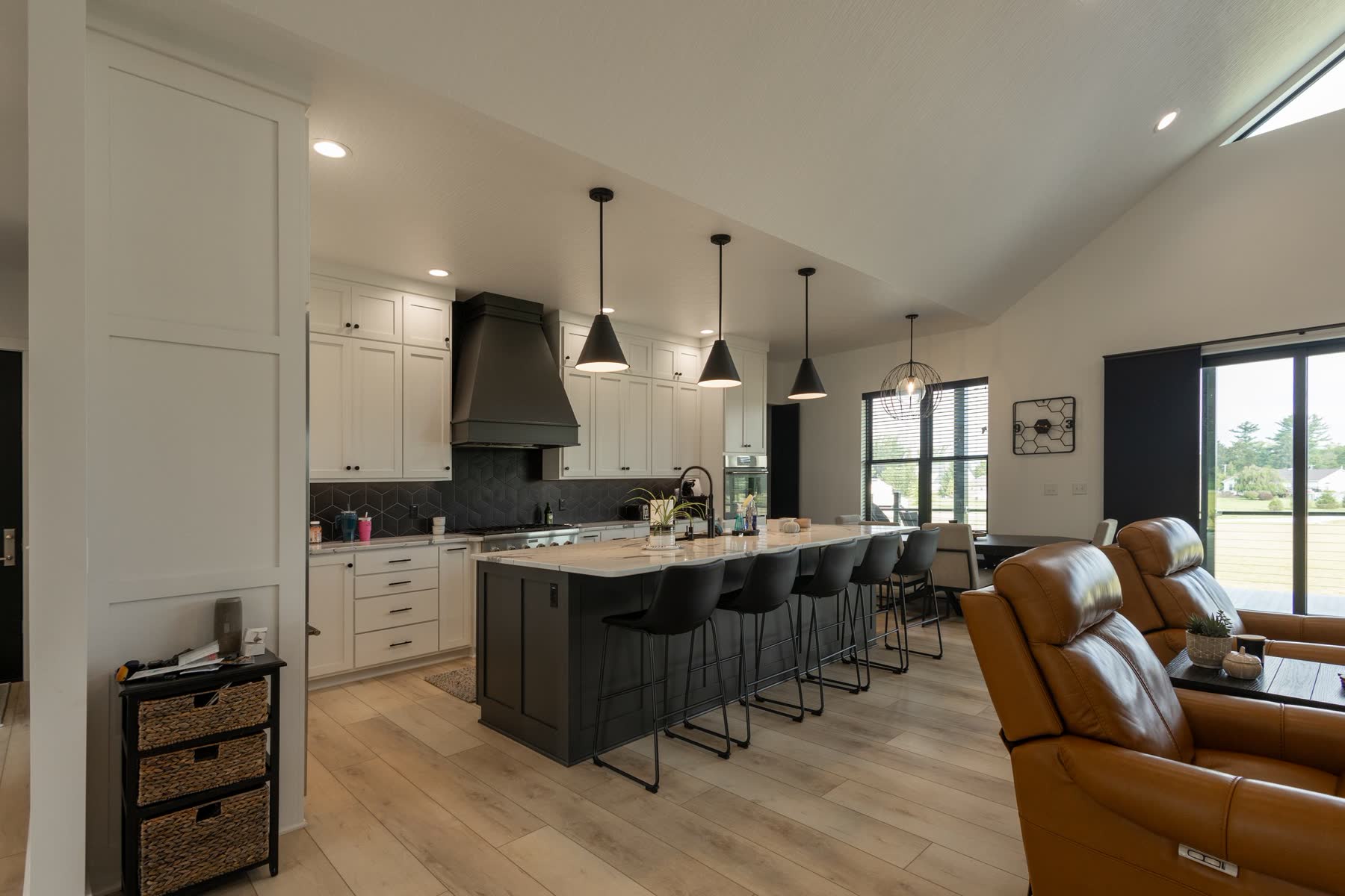 Open-concept kitchen with black island and pendant lighting