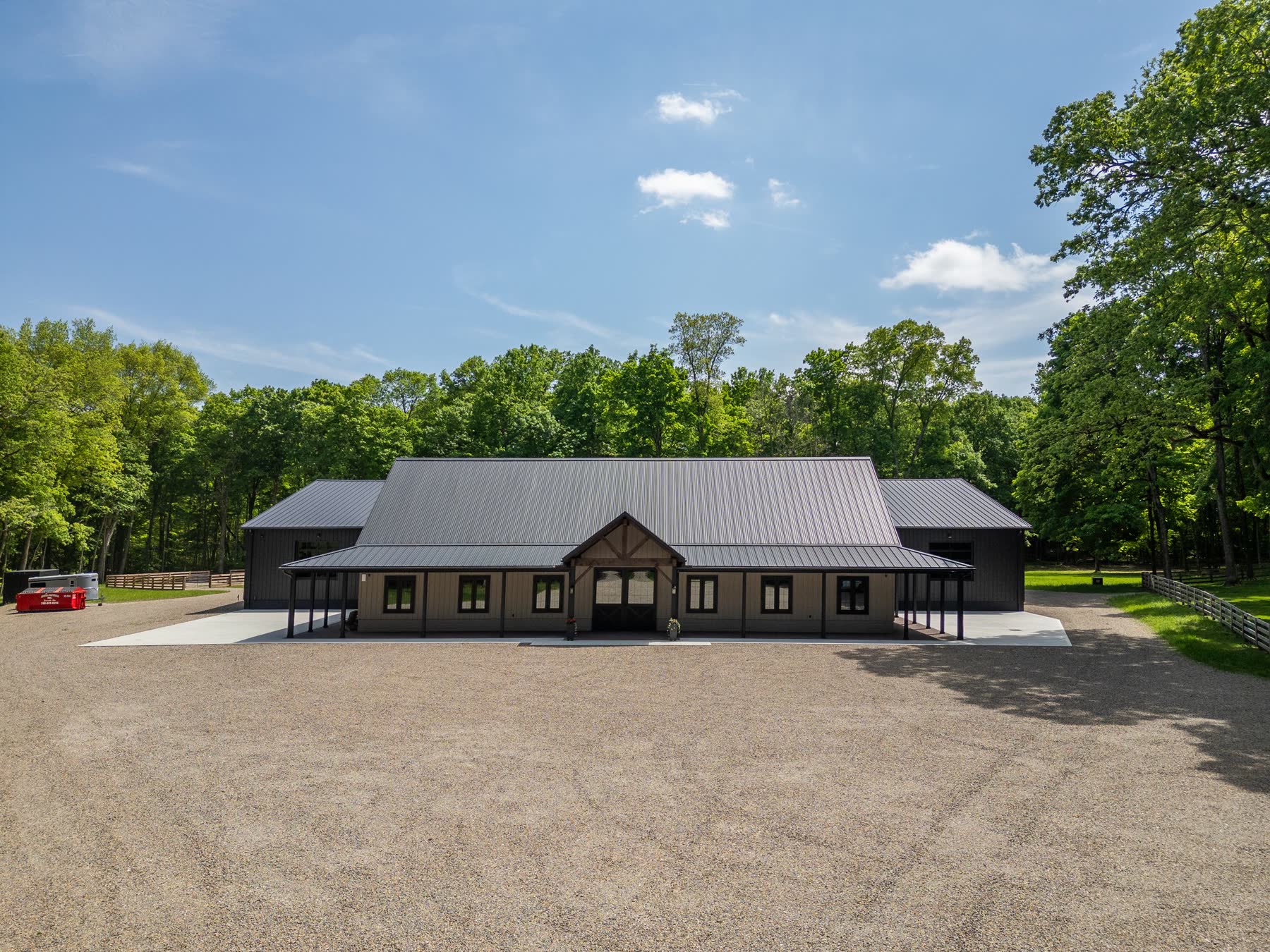 Custom equestrian barn with covered entry and gravel drive