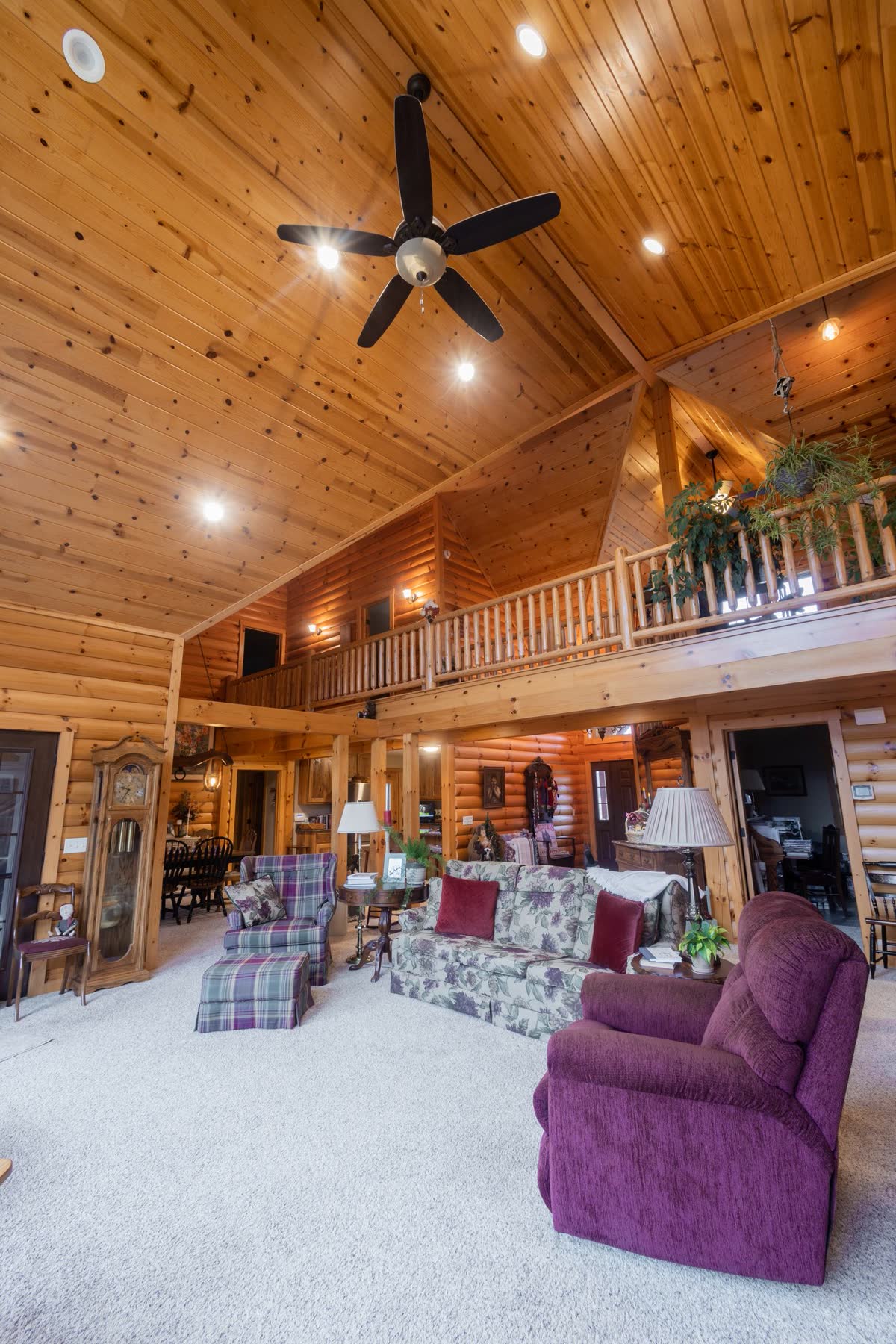 Two-story log home great room with open loft above