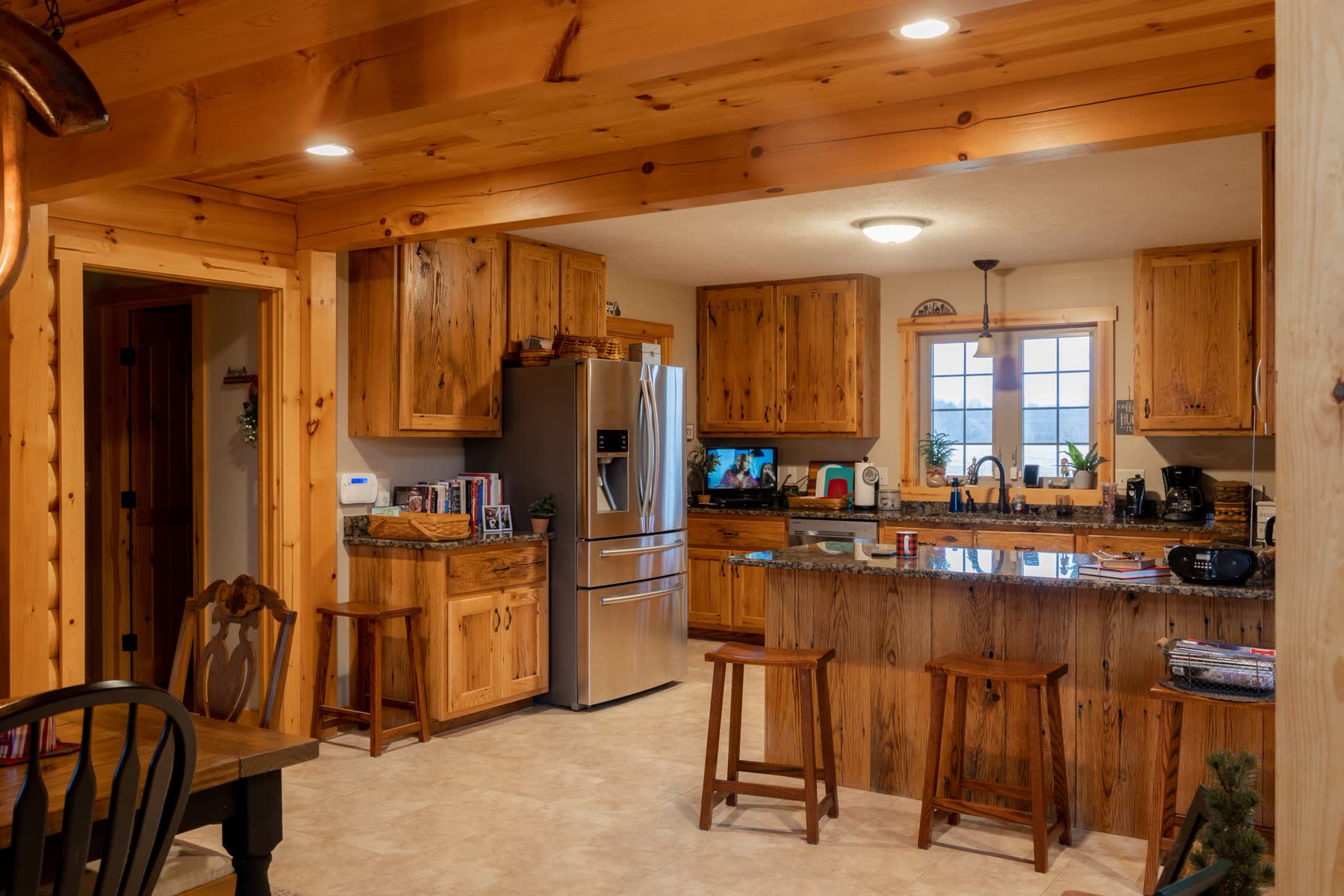 Log home kitchen with rustic wood cabinetry