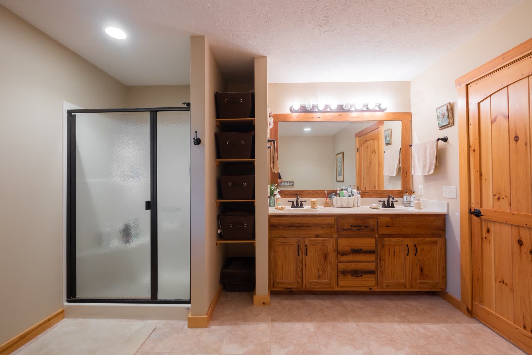 Log home bathroom with wood-framed mirror and vanity