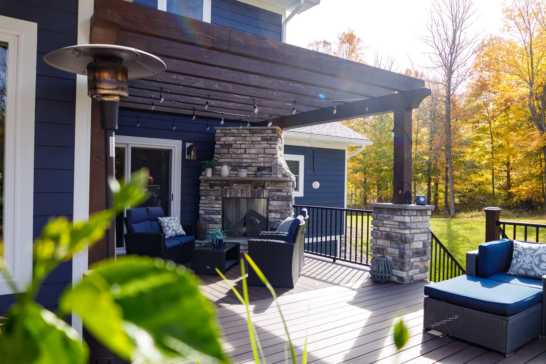 Covered outdoor living space with stone fireplace and pergola