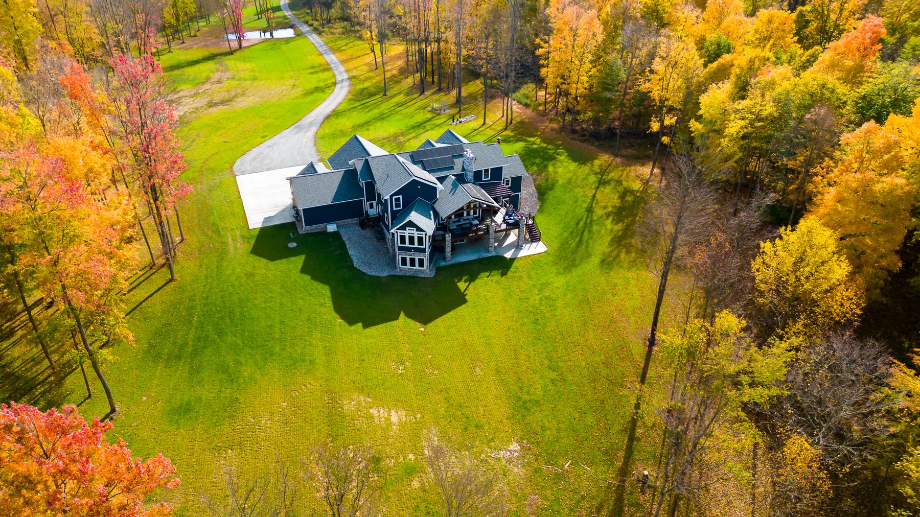 Aerial view of a luxury home surrounded by fall foliage