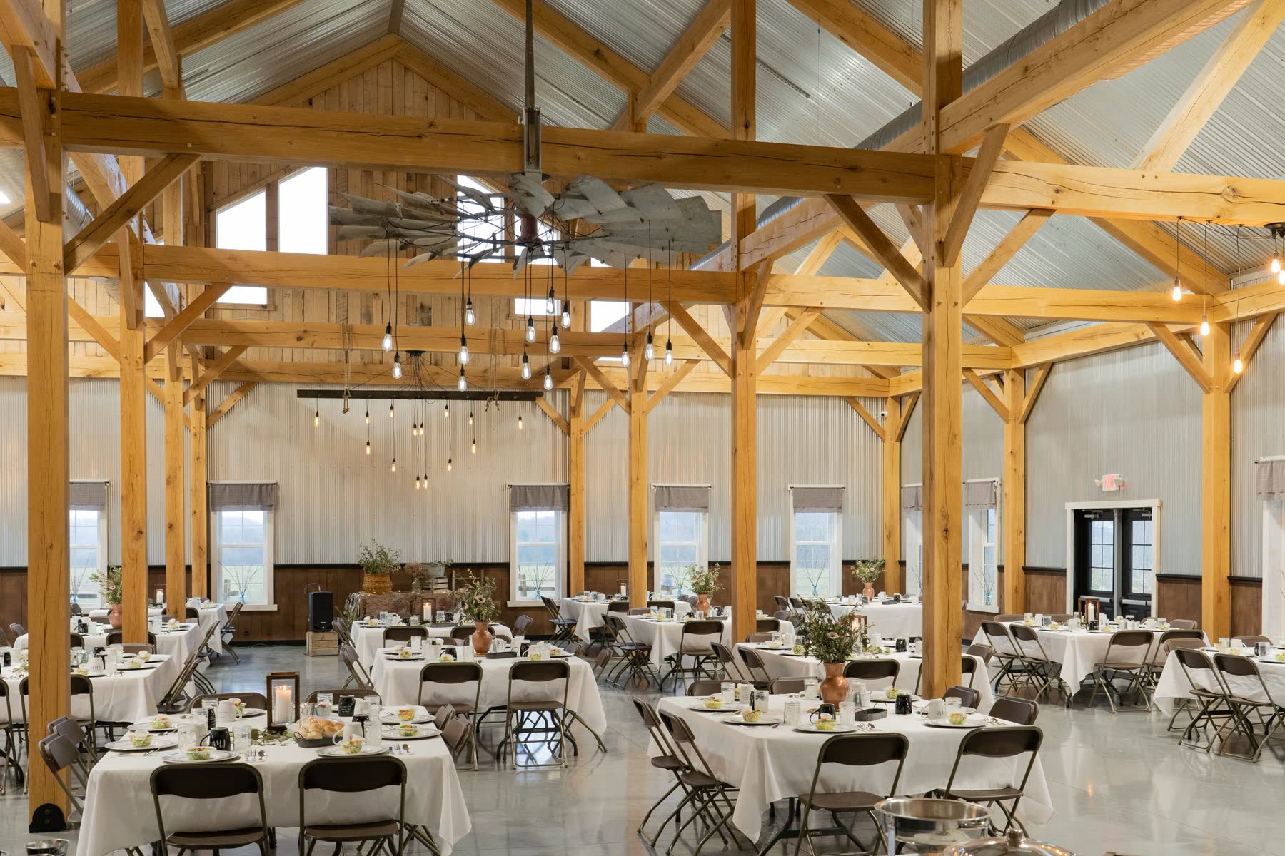 Timber-frame event hall set for a reception dinner