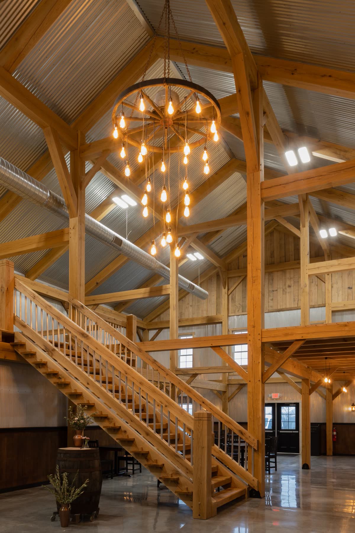 Event venue staircase beneath a wagon-wheel chandelier
