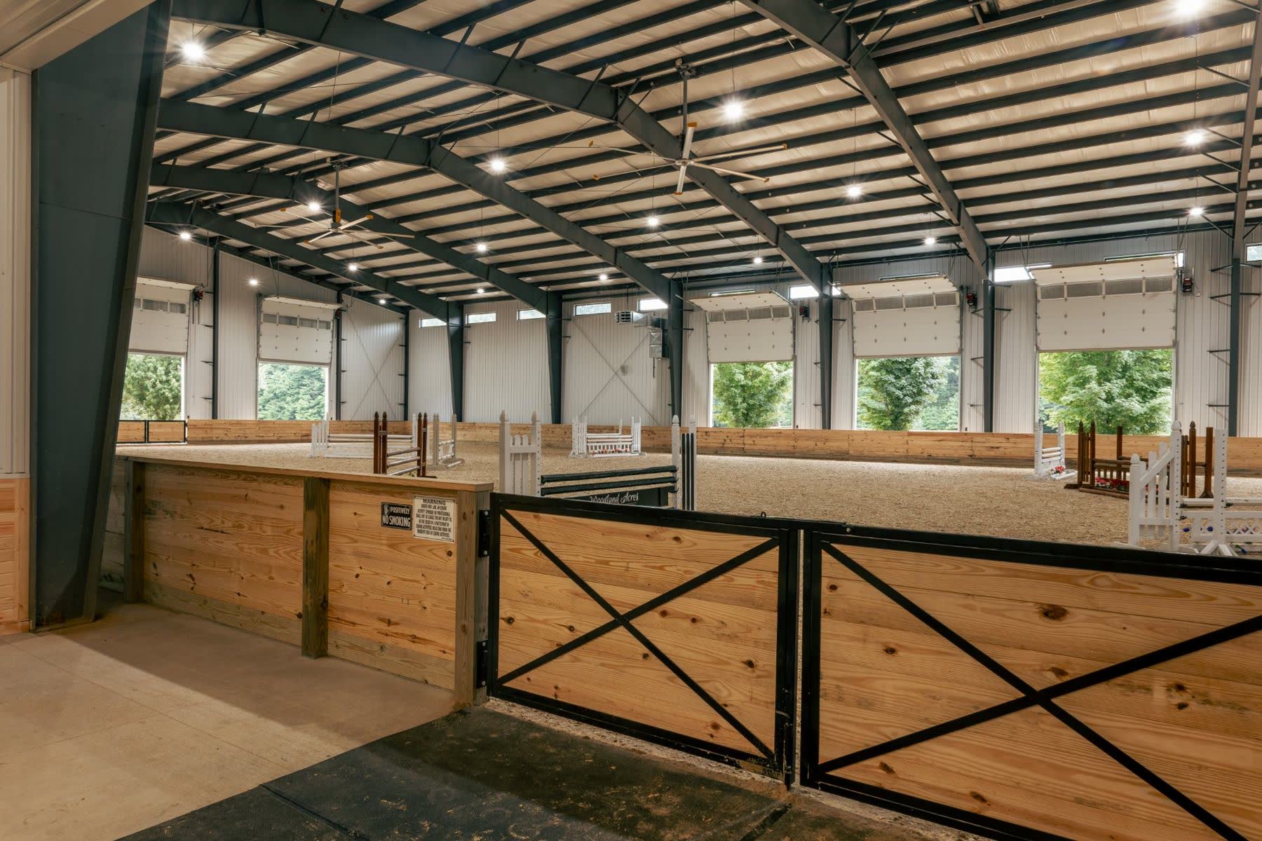 Clear-span steel indoor riding arena with jumps
